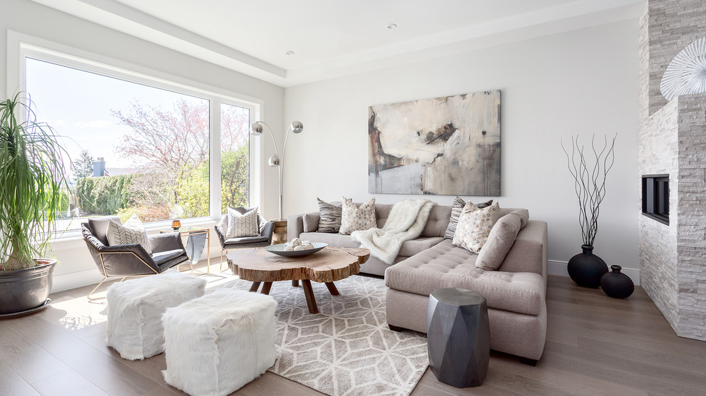 This is an example of a large contemporary open concept living room in Vancouver with white walls, brown floor, medium hardwood floors, a two-sided fireplace and a stone fireplace surround.