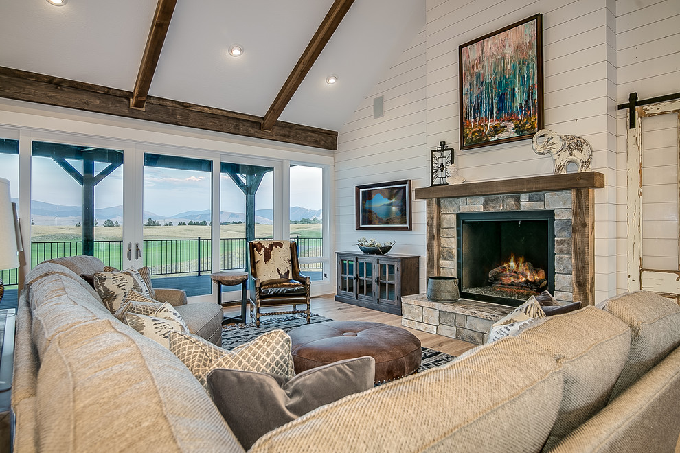 This is an example of a large country formal open concept living room in Other with grey walls, light hardwood floors, a standard fireplace, a stone fireplace surround, no tv and beige floor.