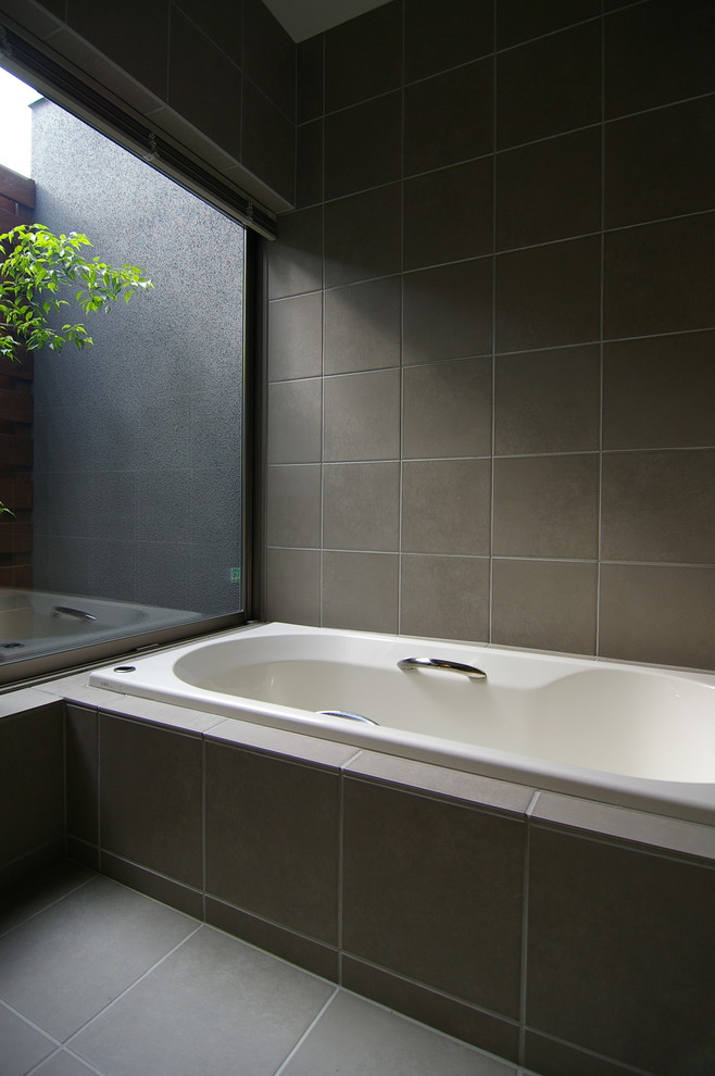 Photo of a midcentury bathroom in Other with a corner tub and grey floor.