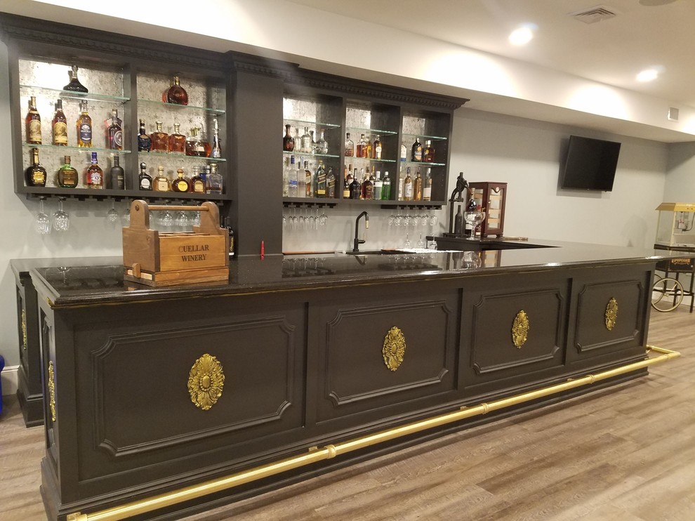 This is an example of a traditional l-shaped seated home bar in New York with shaker cabinets, marble benchtops and black benchtop.