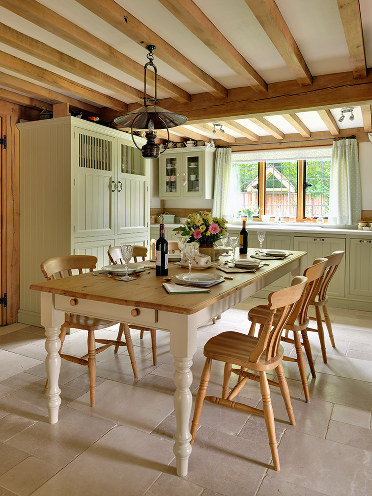 This is an example of a mid-sized traditional kitchen/dining combo in Other with limestone floors, beige floor and white walls.
