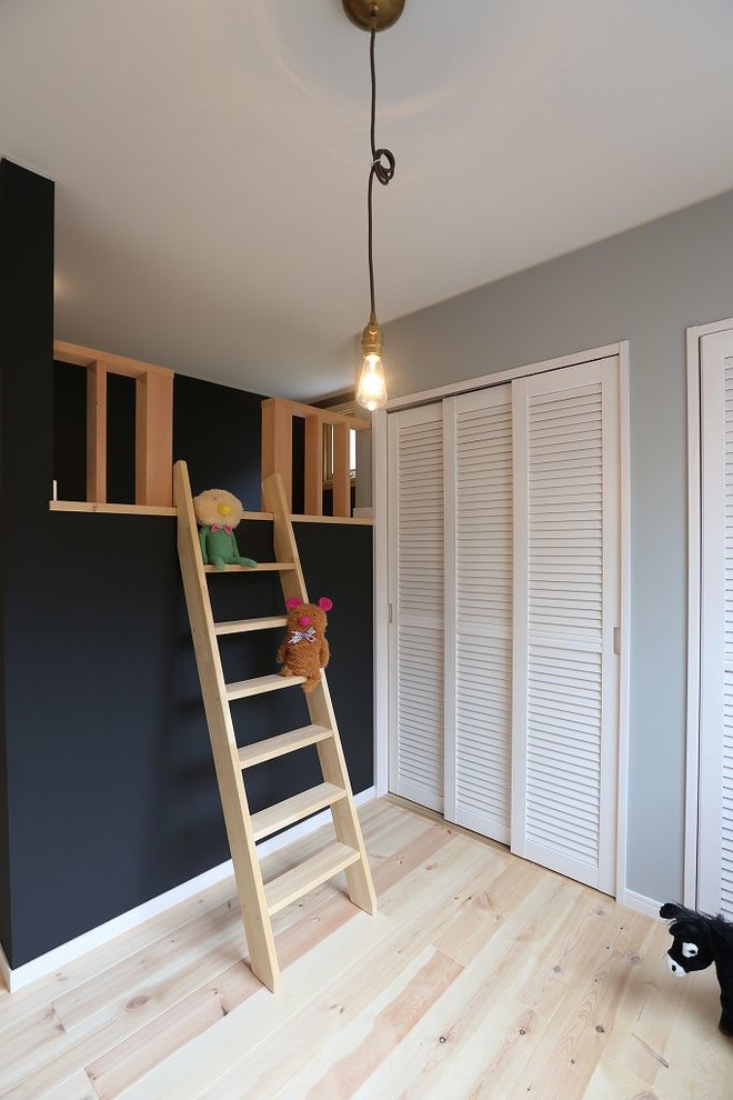 Photo of an asian toddler room for boys in Other with multi-coloured walls and medium hardwood floors.