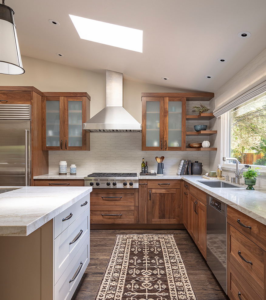 Contemporary l-shaped kitchen in San Francisco with an undermount sink, shaker cabinets, medium wood cabinets, white splashback, dark hardwood floors, with island, brown floor and white benchtop.