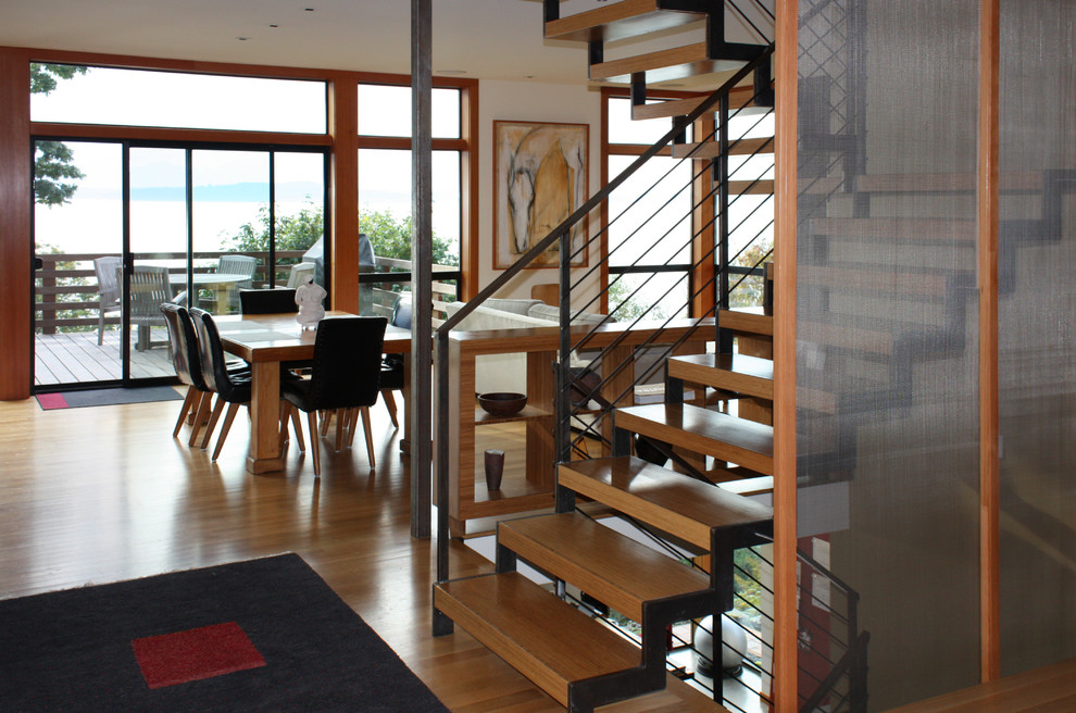 Photo of a mid-sized contemporary wood staircase with open risers and metal railing.