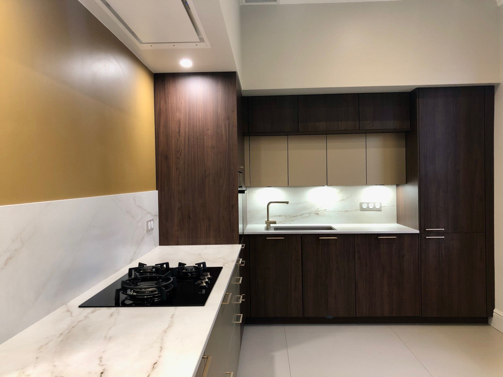 This is an example of a large contemporary u-shaped open plan kitchen in Other with white splashback, ceramic flooring, an island, beige floors and white worktops.