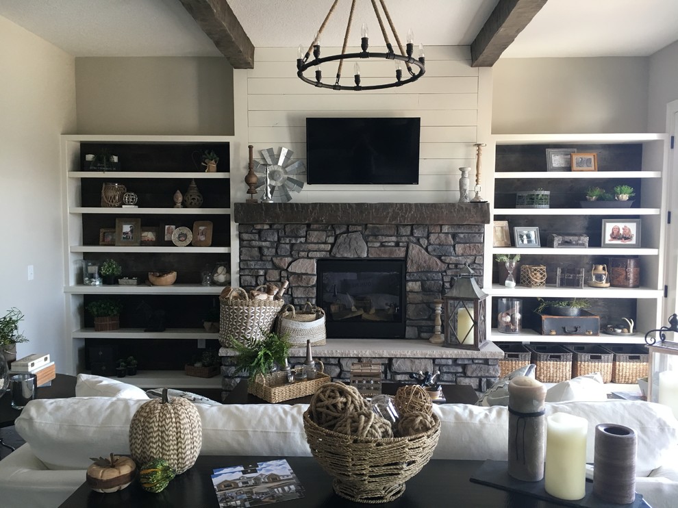 This is an example of a country open concept family room in Other with vinyl floors, a standard fireplace, a stone fireplace surround, a wall-mounted tv and brown floor.