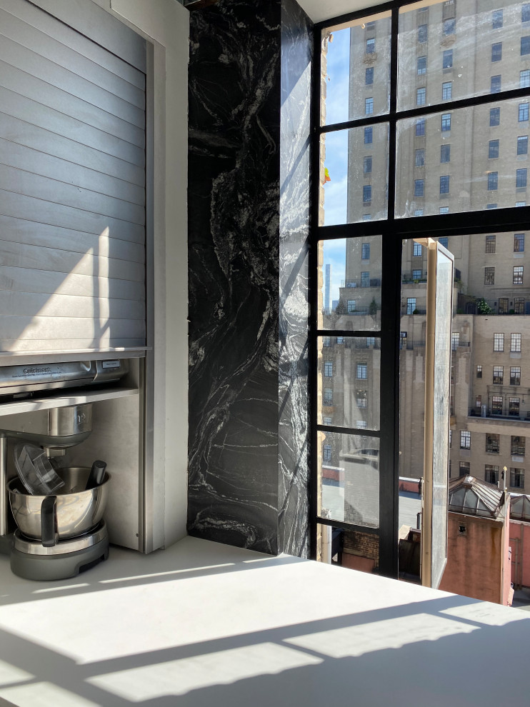 Inspiration for a large traditional kitchen in New York with flat-panel cabinets, white cabinets, quartz benchtops, black splashback and granite splashback.