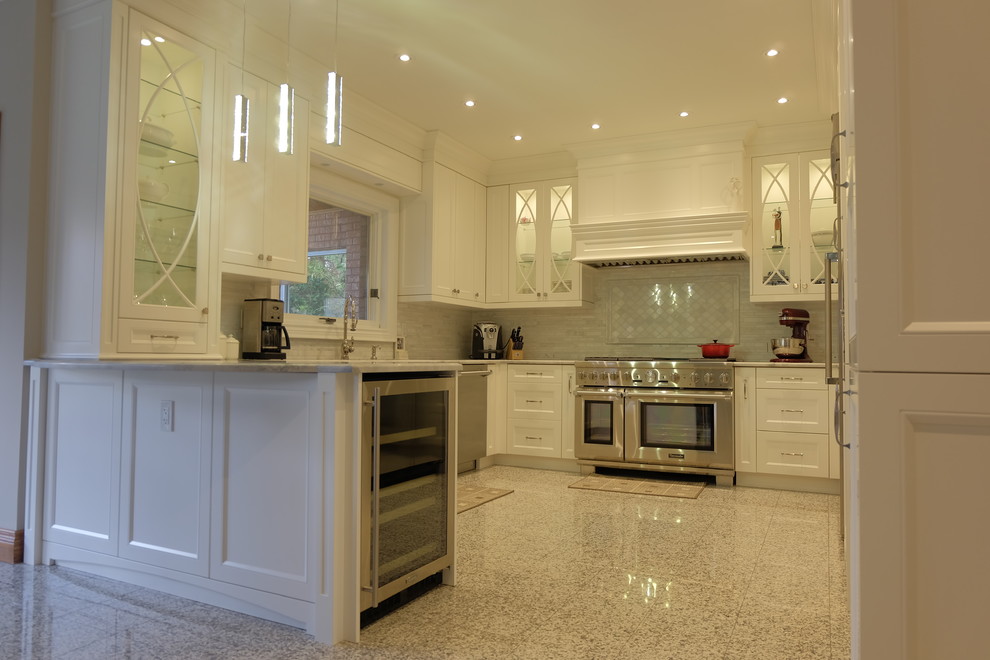 Photo of a large transitional u-shaped kitchen pantry in Toronto with an undermount sink, recessed-panel cabinets, white cabinets, quartz benchtops, grey splashback, mosaic tile splashback, stainless steel appliances, marble floors and a peninsula.