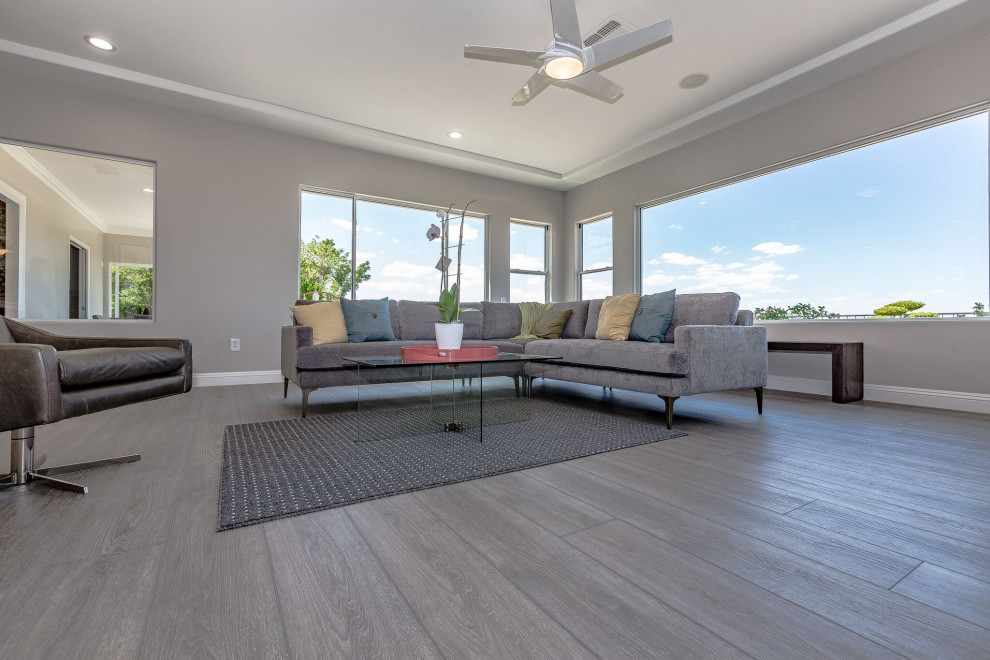 Photo of an expansive asian open concept living room in Las Vegas with vinyl floors, grey floor, grey walls, no fireplace and a wall-mounted tv.