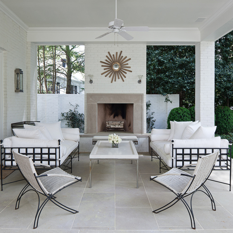 Photo of a mid-sized transitional backyard patio in Atlanta with natural stone pavers and a roof extension.