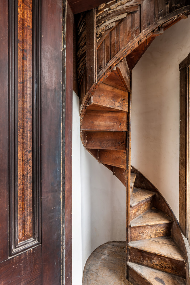 Inspiration for a small traditional wood spiral staircase in Other with wood risers.
