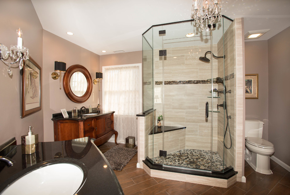 Design ideas for a large traditional master bathroom in Baltimore with medium wood cabinets, a one-piece toilet, brown tile, ceramic tile, beige walls, ceramic floors, an undermount sink, granite benchtops, recessed-panel cabinets and an alcove shower.