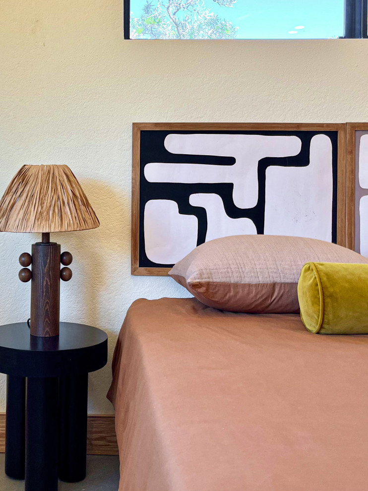 Mediterranes Gästezimmer mit beiger Wandfarbe, Betonboden und grauem Boden in Los Angeles