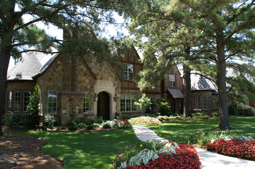 Large traditional two-storey beige exterior in Dallas with stone veneer and a gable roof.