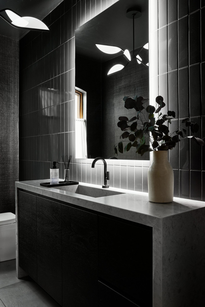 Inspiration för moderna grått toaletter, med släta luckor, svarta skåp, svart kakel, keramikplattor, svarta väggar, ett integrerad handfat, bänkskiva i kalksten och grått golv