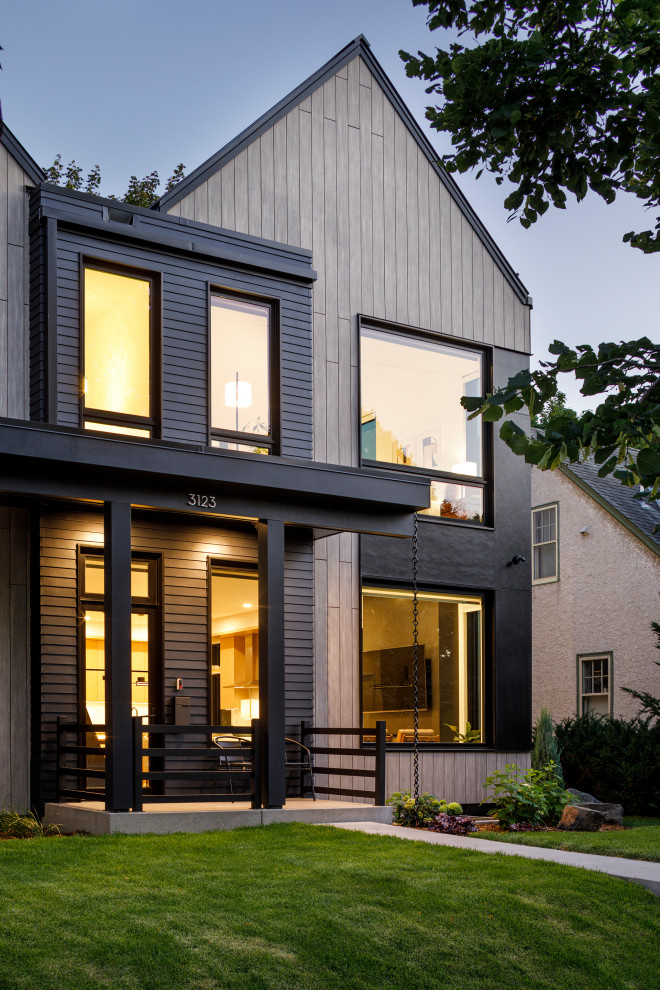 Inspiration for a mid-sized scandinavian two-storey beige townhouse exterior in Minneapolis with mixed siding, a gable roof, a metal roof and a black roof.