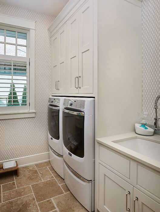 Photo of a large traditional single-wall dedicated laundry room in Grand Rapids with an undermount sink, shaker cabinets, beige cabinets, quartz benchtops, beige walls, ceramic floors, a side-by-side washer and dryer, brown floor and beige benchtop.
