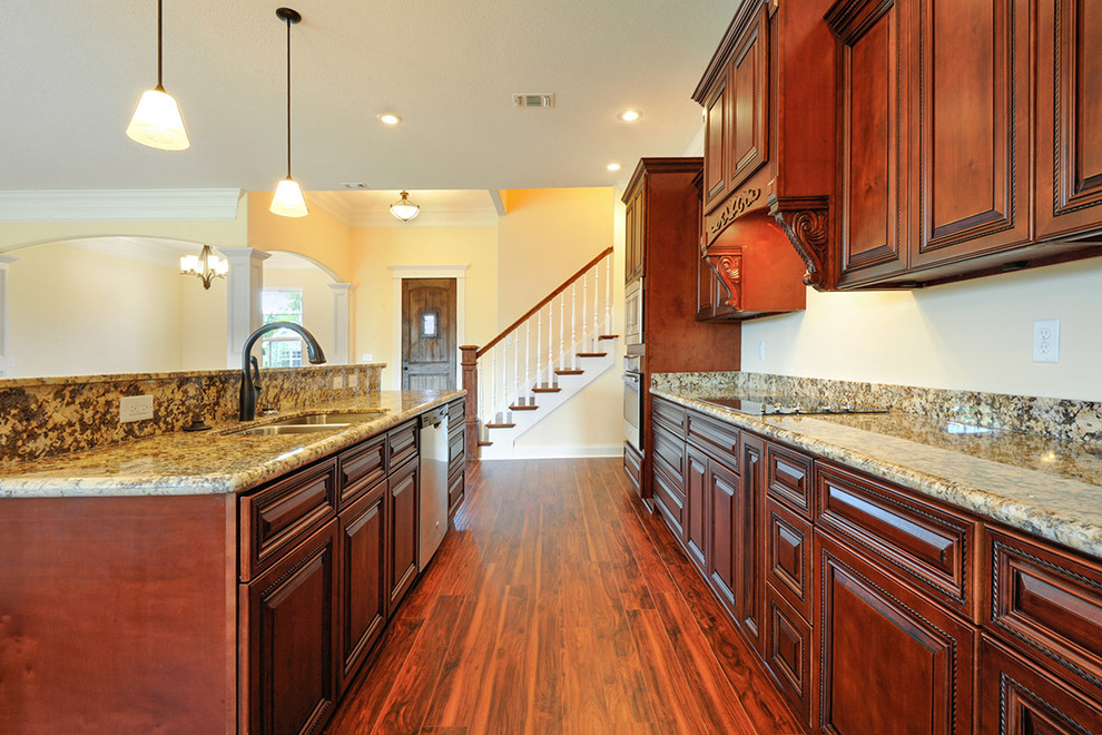 Mid-sized transitional galley medium tone wood floor open concept kitchen photo with an undermount sink, beaded inset cabinets, medium tone wood cabinets, granite countertops, stainless steel appliances and an island