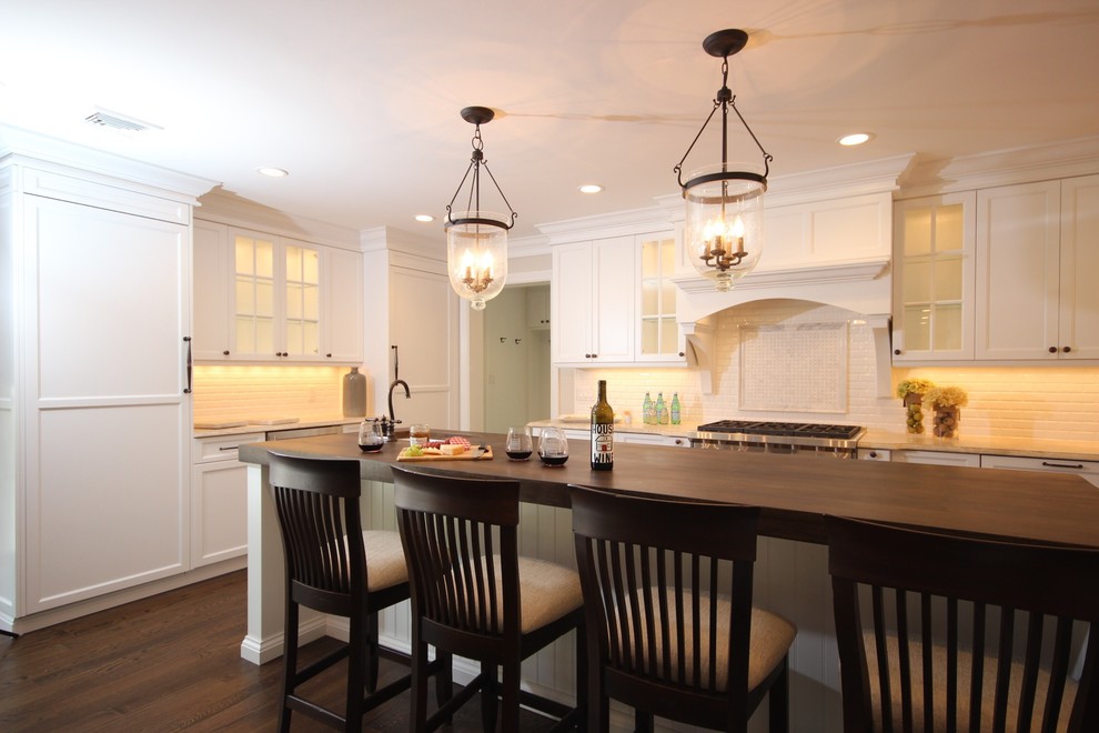 Inspiration for a large transitional l-shaped dark wood floor open concept kitchen remodel in New York with a farmhouse sink, shaker cabinets, white cabinets, concrete countertops, white backsplash, subway tile backsplash, stainless steel appliances and an island