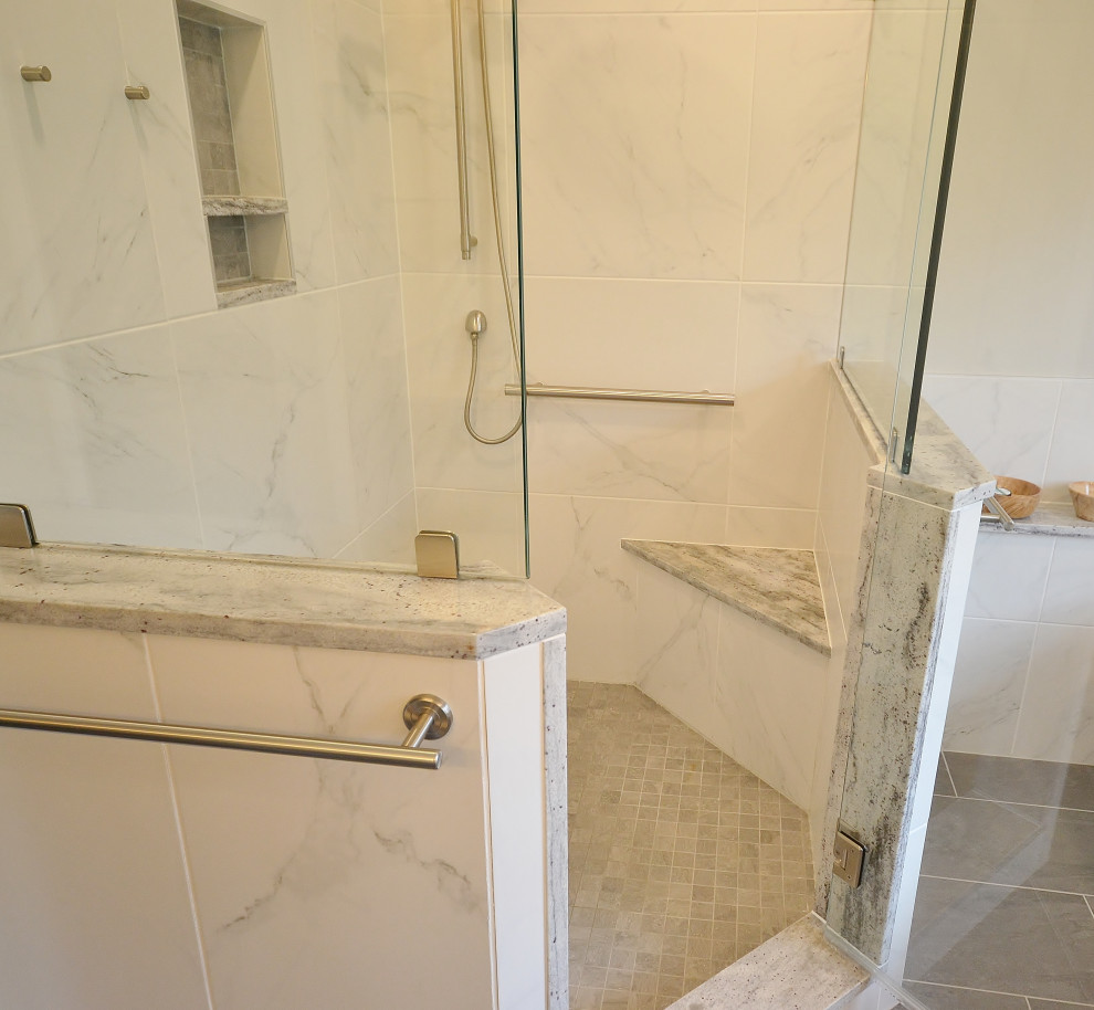 This is an example of a large transitional master bathroom in Philadelphia with raised-panel cabinets, grey cabinets, a freestanding tub, a corner shower, a one-piece toilet, multi-coloured tile, ceramic tile, white walls, ceramic floors, an undermount sink, granite benchtops, grey floor, a hinged shower door and multi-coloured benchtops.