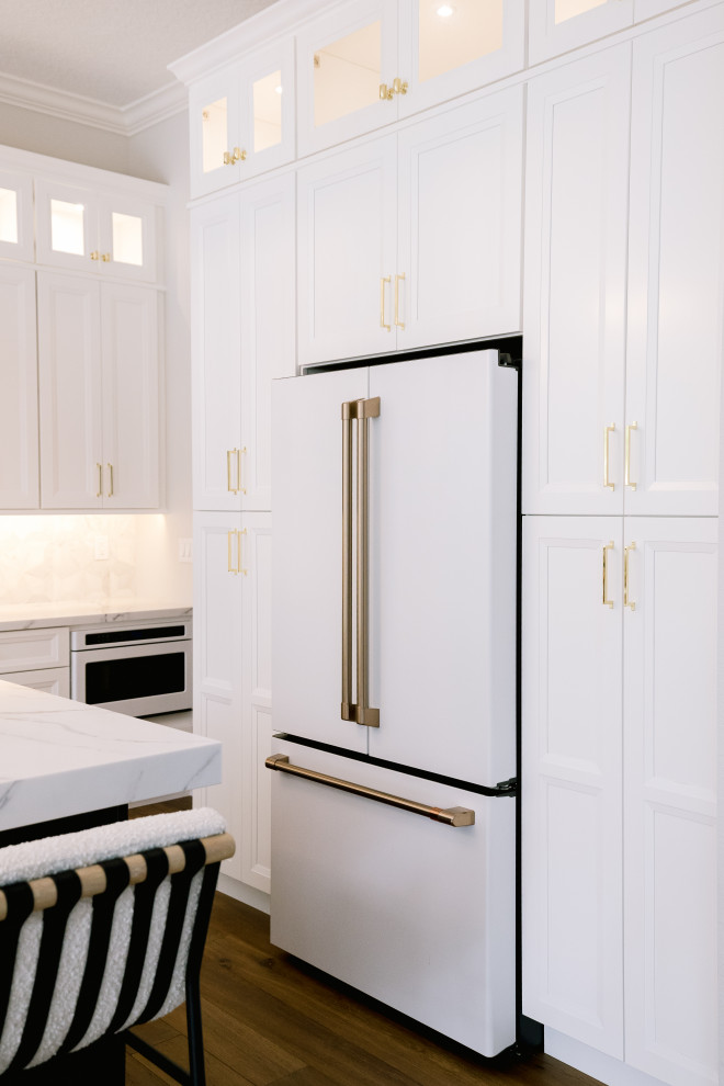 Large transitional u-shaped medium tone wood floor and brown floor eat-in kitchen photo in Orlando with a drop-in sink, beaded inset cabinets, white cabinets, quartz countertops, gray backsplash, marble backsplash, white appliances, an island and white countertops