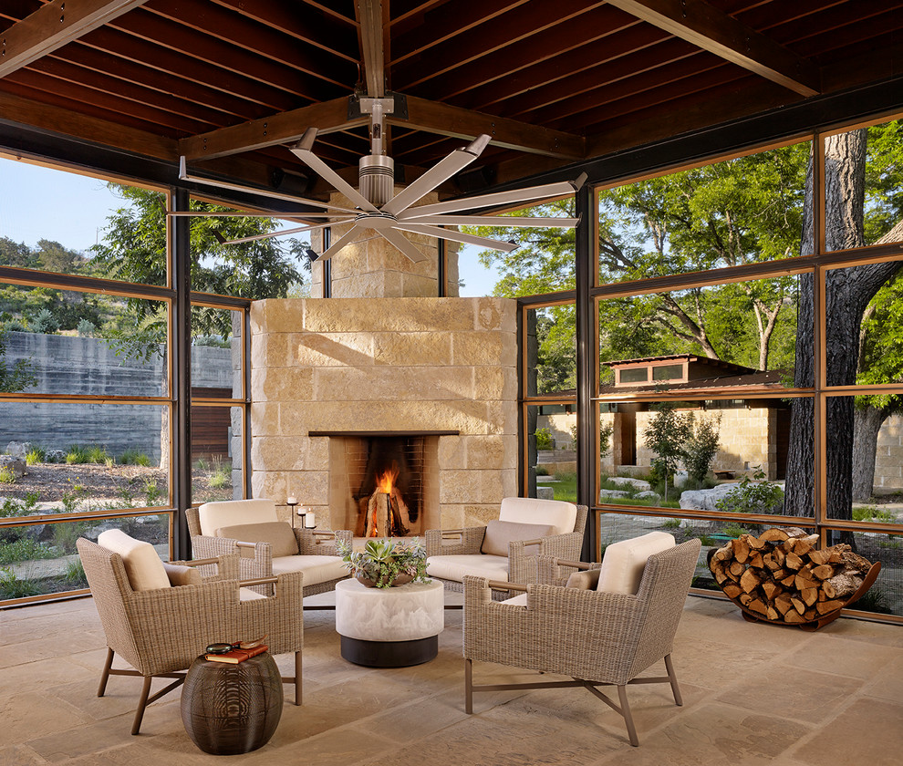 Photo of a contemporary sunroom in Houston with a corner fireplace, a stone fireplace surround, a standard ceiling and beige floor.