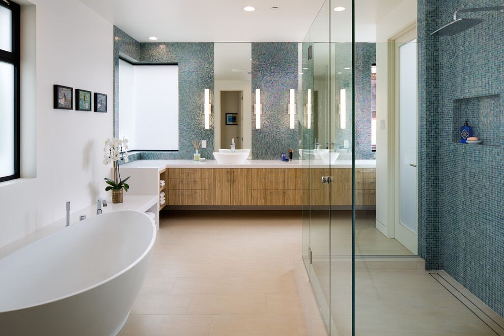 Design ideas for a large contemporary master bathroom in San Diego with flat-panel cabinets, a freestanding tub, blue tile, mosaic tile, white walls, porcelain floors, a vessel sink, engineered quartz benchtops, beige floor, a hinged shower door, medium wood cabinets and a corner shower.