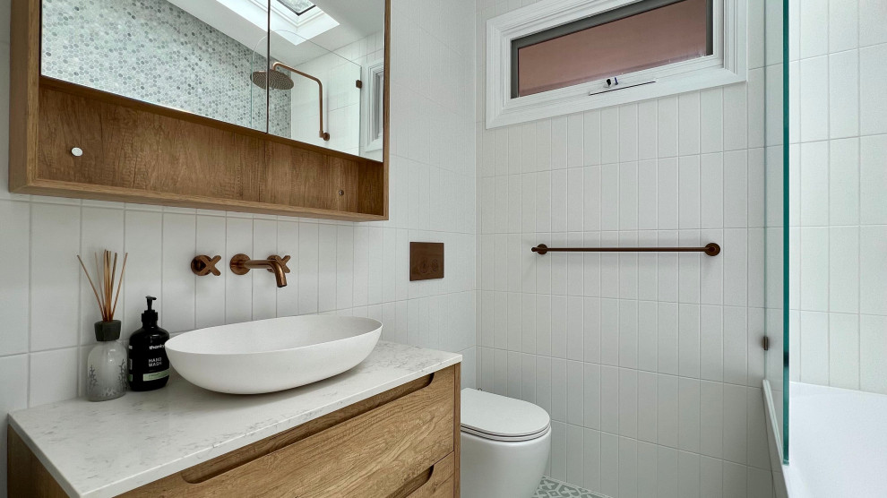 Идея дизайна: маленькая главная ванная комната в современном стиле с фасадами островного типа, коричневыми фасадами, угловой ванной, душем над ванной, инсталляцией, белой плиткой, керамической плиткой, белыми стенами, полом из керамической плитки, консольной раковиной, столешницей из искусственного кварца, зеленым полом, открытым душем, белой столешницей, тумбой под одну раковину и подвесной тумбой для на участке и в саду