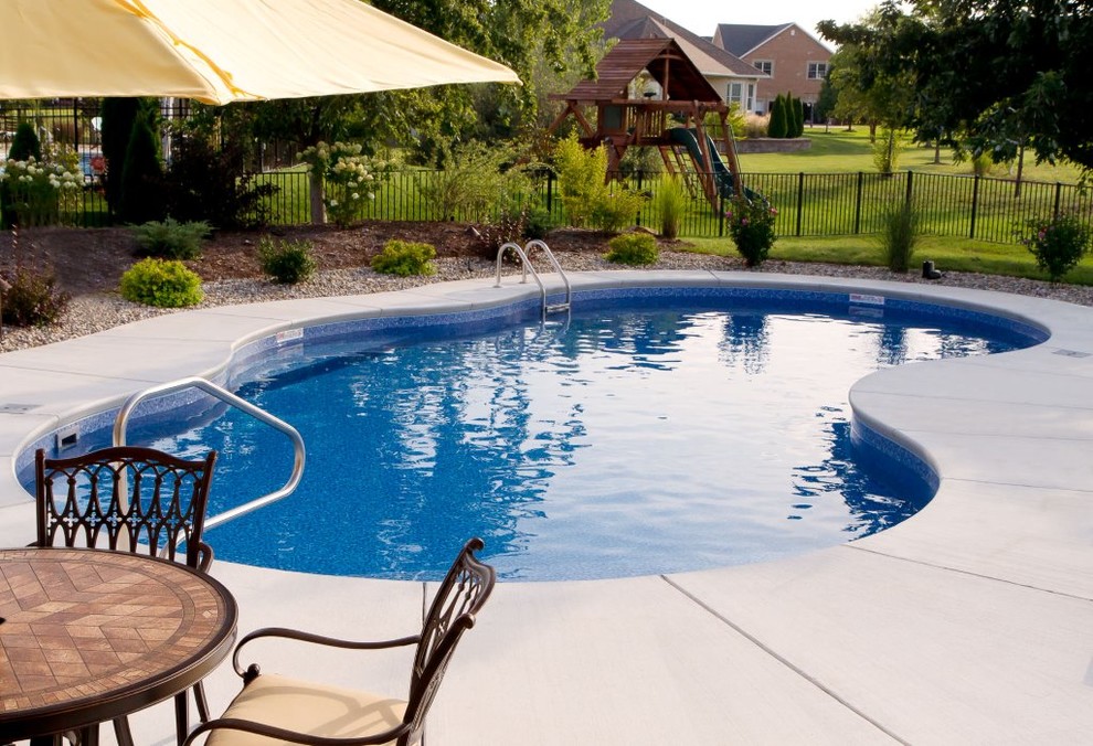Design ideas for a mid-sized transitional backyard custom-shaped lap pool in St Louis with concrete pavers.