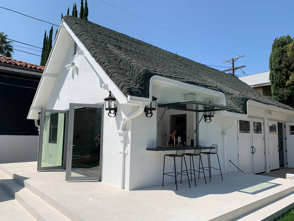Kleines, Einstöckiges Modernes Einfamilienhaus mit Putzfassade, weißer Fassadenfarbe, Pultdach, Schindeldach und grauem Dach in Los Angeles