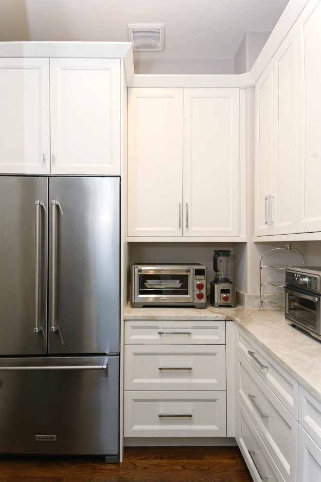 Example of a huge transitional medium tone wood floor and brown floor eat-in kitchen design with an undermount sink, recessed-panel cabinets, white cabinets, quartzite countertops, white backsplash, ceramic backsplash, stainless steel appliances, an island and white countertops