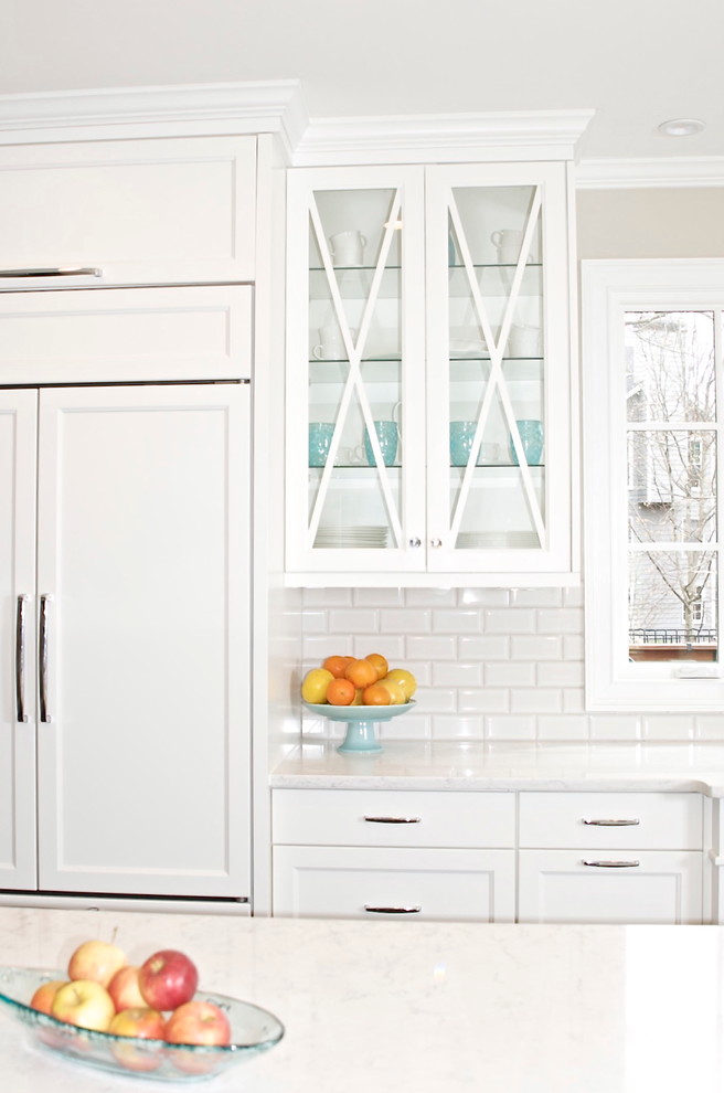Example of a mid-sized transitional u-shaped dark wood floor eat-in kitchen design in Atlanta with an undermount sink, glass-front cabinets, white cabinets, quartz countertops, white backsplash, subway tile backsplash, paneled appliances and an island