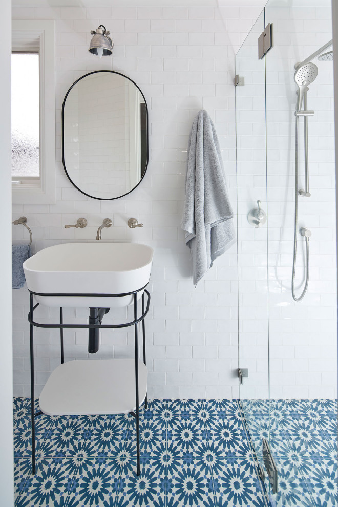 Photo of a large beach style 3/4 bathroom in Central Coast with open cabinets, black cabinets, a corner shower, white tile, stone tile, white walls, ceramic floors, a console sink, blue floor, a hinged shower door, a single vanity and a freestanding vanity.