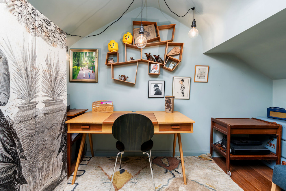 Photo of an eclectic home office in Manchester with blue walls, dark hardwood flooring, a freestanding desk and brown floors.