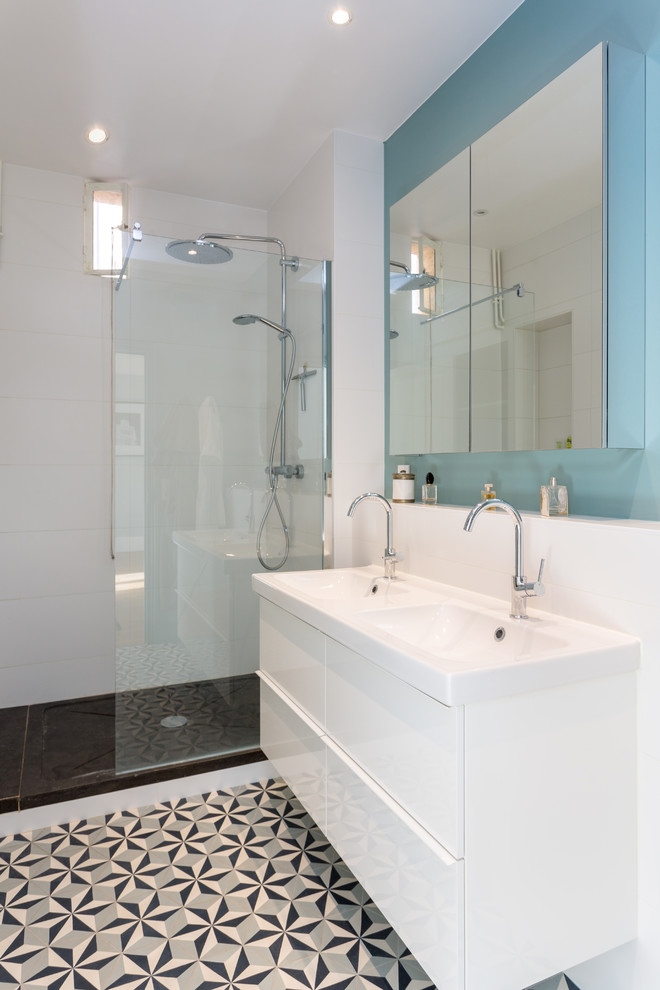 This is an example of a mid-sized contemporary master bathroom in Paris with white cabinets, a curbless shower, white walls, an open shower, flat-panel cabinets, white tile, ceramic tile, cement tiles, a console sink, solid surface benchtops, multi-coloured floor and white benchtops.