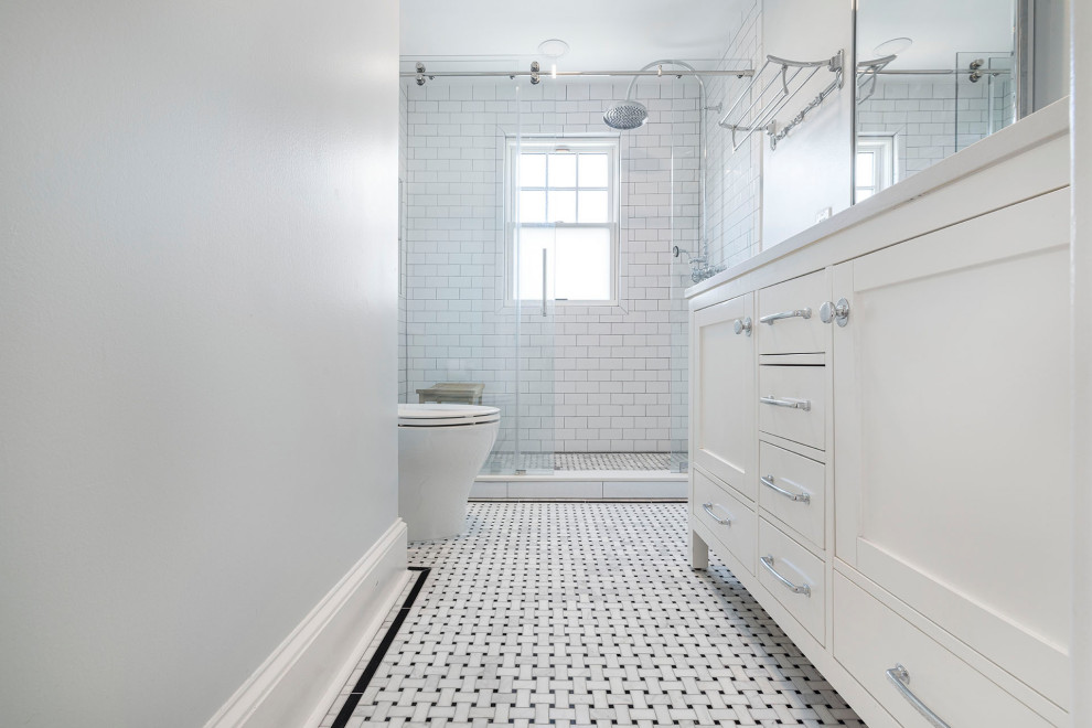 Design ideas for a mid-sized traditional master bathroom in DC Metro with an alcove shower, a two-piece toilet, white tile, subway tile, grey walls, porcelain floors, an undermount sink, engineered quartz benchtops, white floor, white benchtops, a niche, a double vanity, shaker cabinets, white cabinets, a sliding shower screen and a freestanding vanity.