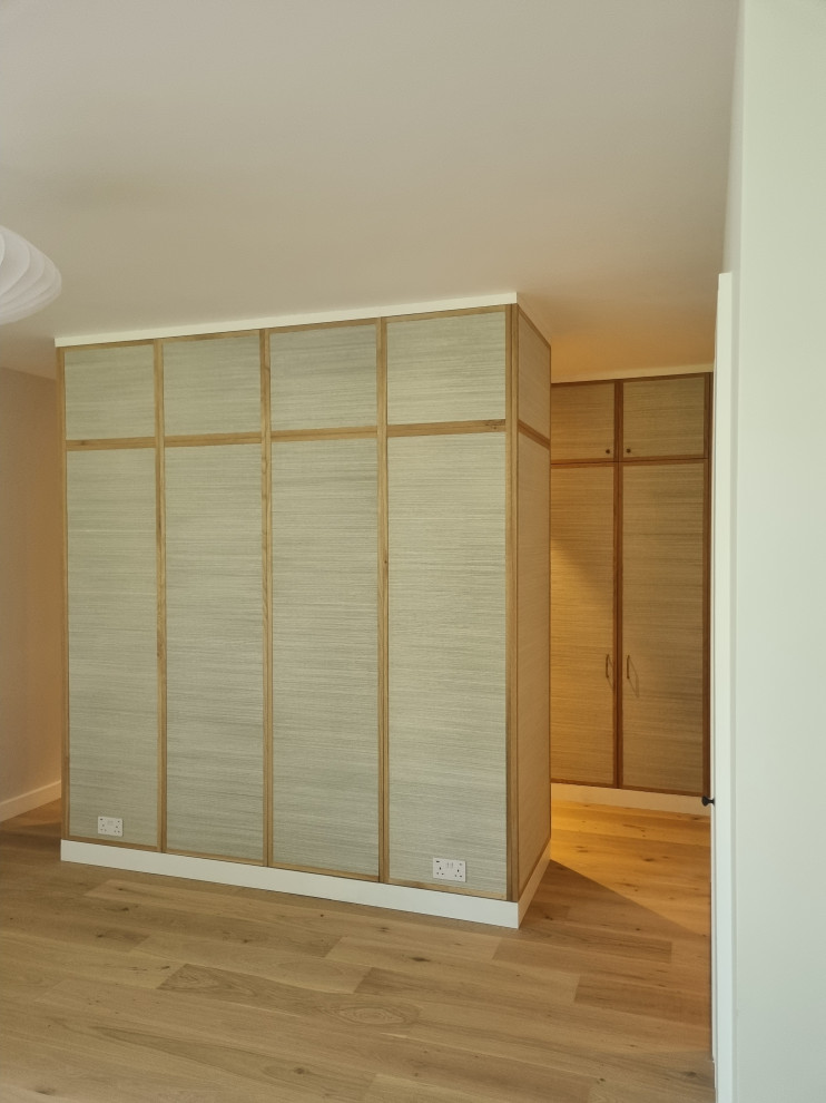 Réalisation d'une grande chambre parentale minimaliste avec un mur beige et un sol en contreplaqué.