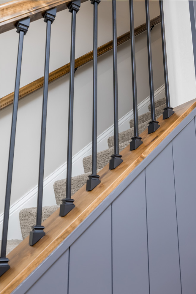 Foto de escalera recta de tamaño medio con escalones enmoquetados, contrahuellas enmoquetadas, barandilla de metal y machihembrado