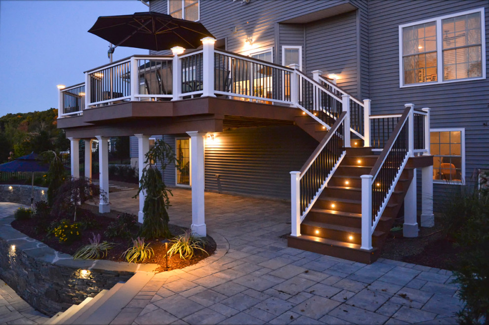 This is an example of a large arts and crafts backyard and first floor deck in New York with no cover and mixed railing.