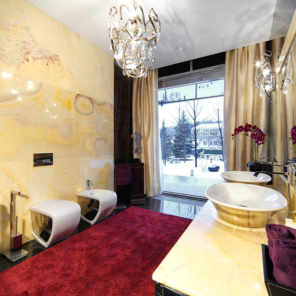 Inspiration for a large contemporary bathroom in New York with a two-piece toilet, yellow walls, a vessel sink, glass-front cabinets, grey cabinets, yellow tile, stone slab, marble floors and onyx benchtops.