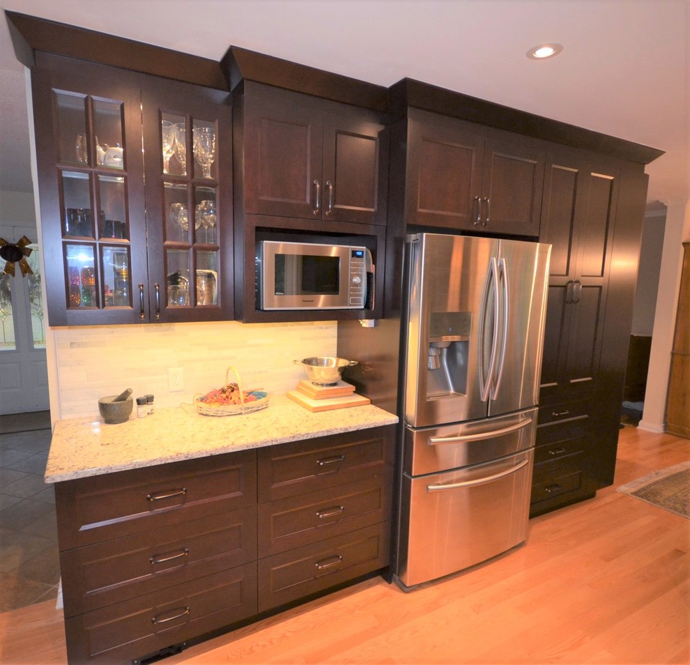 Example of a mid-sized transitional galley medium tone wood floor and brown floor eat-in kitchen design in Ottawa with recessed-panel cabinets, dark wood cabinets, granite countertops, gray backsplash, stainless steel appliances, a double-bowl sink, porcelain backsplash, a peninsula and beige countertops