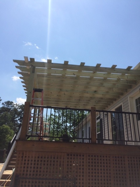 Example of a mid-sized mountain style backyard deck design in Charlotte with a roof extension