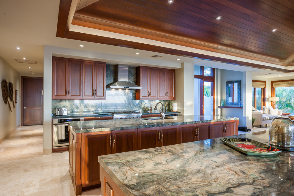 Inspiration for a large tropical kitchen in Hawaii with recessed-panel cabinets, quartzite benchtops, green splashback, glass tile splashback, stainless steel appliances, travertine floors and multiple islands.