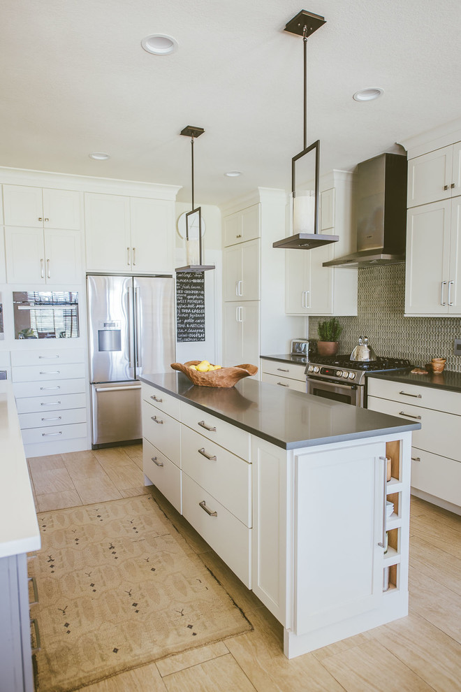 Large transitional u-shaped open plan kitchen in Austin with an undermount sink, shaker cabinets, white cabinets, stainless steel appliances, porcelain floors, multiple islands, solid surface benchtops, grey splashback and glass tile splashback.