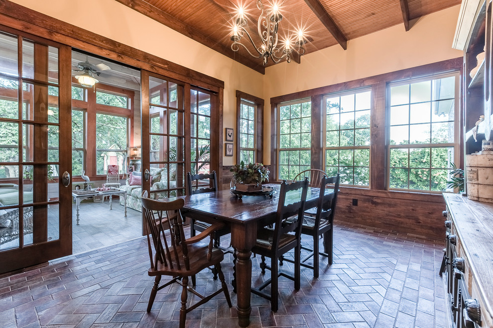This is an example of a large separate dining room in Dallas with beige walls and brick floors.