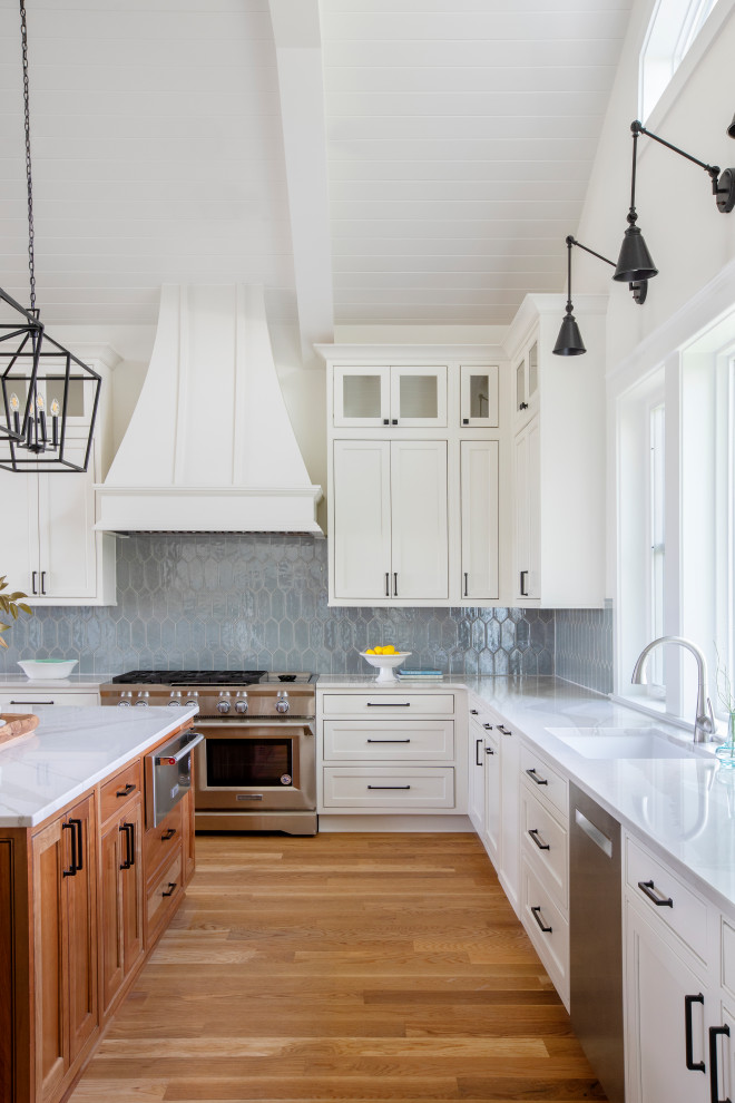 Inspiration for a beach style eat-in kitchen in Charleston with an undermount sink, recessed-panel cabinets, white cabinets, quartz benchtops, blue splashback, stainless steel appliances, with island, grey benchtop and exposed beam.