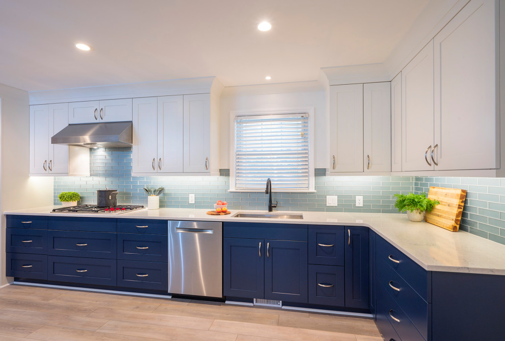 Large transitional u-shaped vinyl floor and beige floor enclosed kitchen photo in Charleston with an undermount sink, recessed-panel cabinets, blue cabinets, quartz countertops, blue backsplash, glass tile backsplash, stainless steel appliances, no island and white countertops