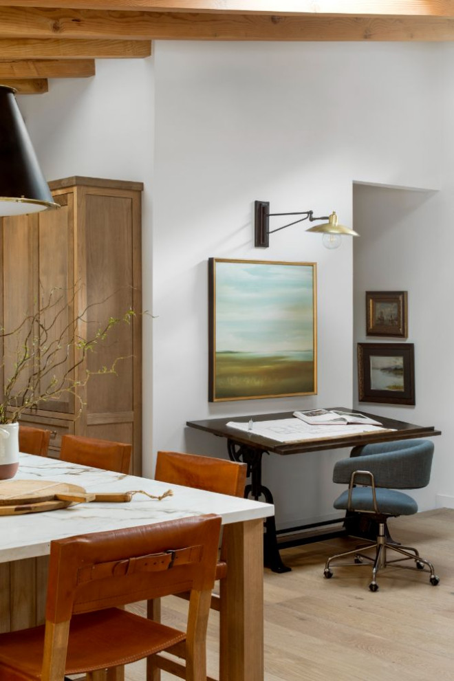 Imagen de sala de manualidades actual de tamaño medio sin chimenea con paredes blancas, suelo de madera en tonos medios y escritorio independiente