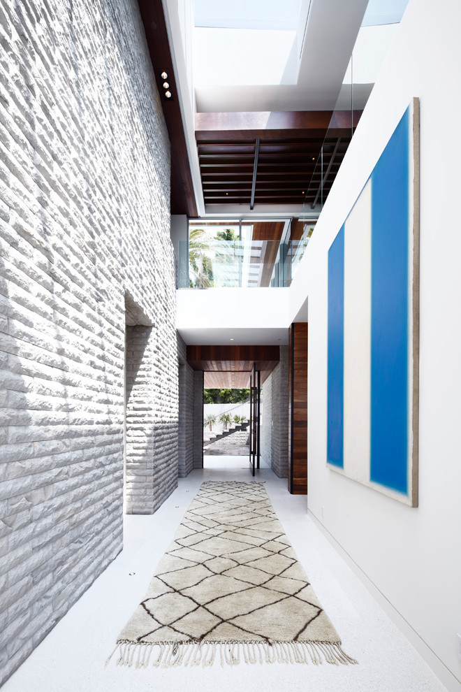 This is an example of an expansive contemporary hallway in Los Angeles with white walls and ceramic floors.