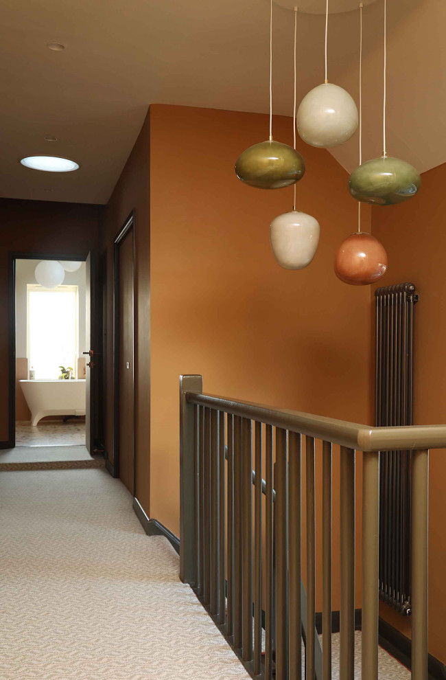 Aménagement d'un couloir rétro de taille moyenne avec un mur marron, moquette et un sol multicolore.